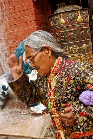 A Buddhist practitioner walks past after spining a prayer wheel