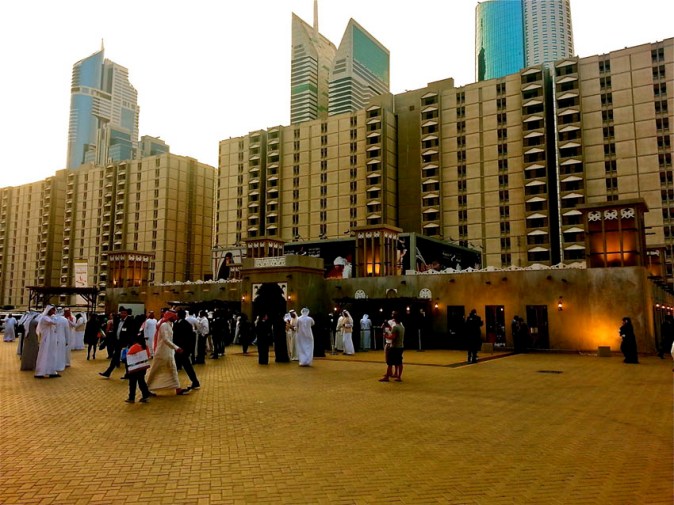 The contrasting backdrop of the WTC apartments against the recreated traditional wind-towered Emirati houses